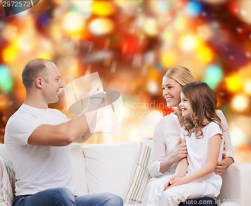 Image of happy family with camera at home