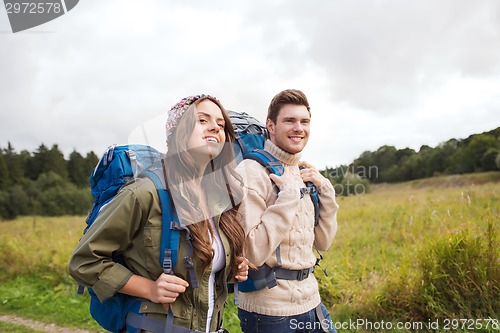 Image of smiling couple with backpacks hiking