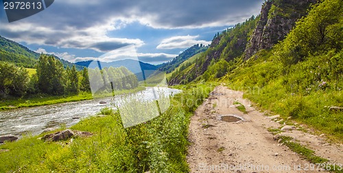 Image of road near river under cloudy sky