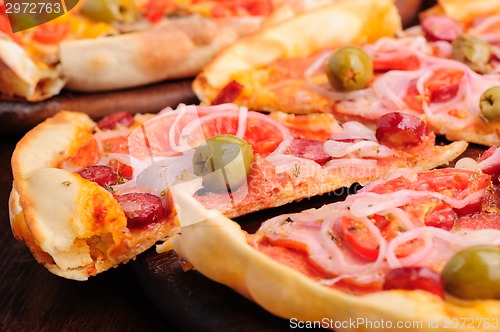 Image of Pizza with tomato, salami, peppeeoni, olives and yellow hot pepper