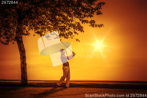 Image of golf player sunset