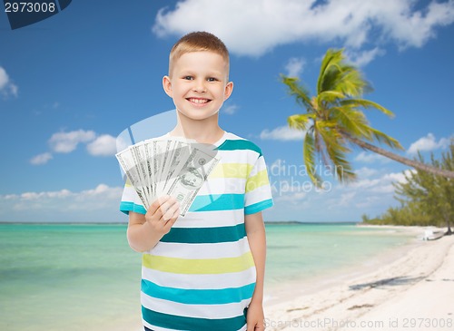 Image of smiling boy holding dollar cash money in his hand