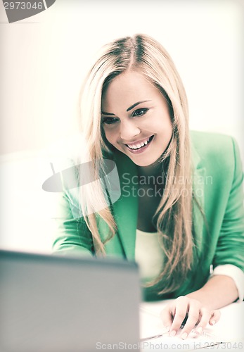 Image of businesswoman with laptop in office