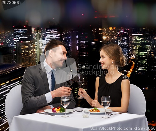 Image of smiling couple eating main course at restaurant