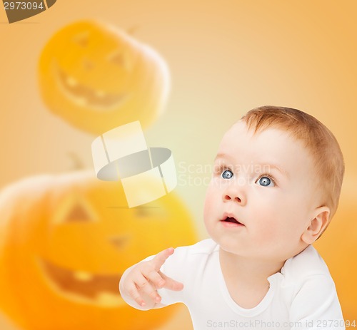 Image of smiling baby over pumpkins background