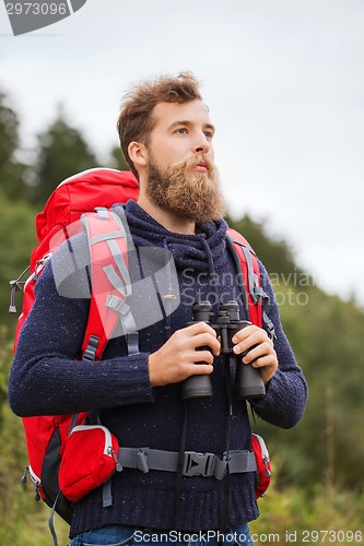 Image of man with backpack and binocular outdoors