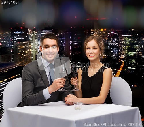 Image of young couple with glasses of wine at restaurant