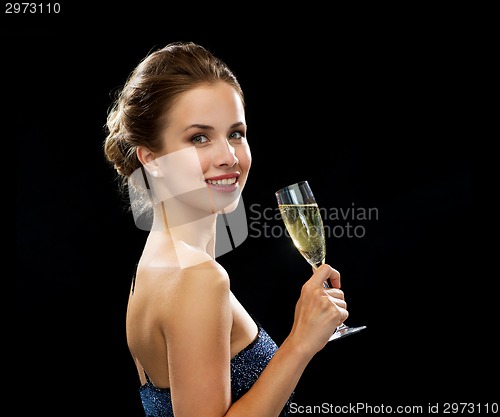Image of smiling woman holding glass of sparkling wine