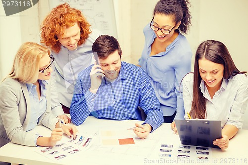 Image of creative team with papers and clipboard at office