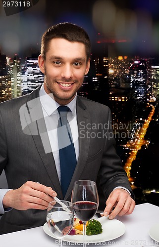 Image of smiling man eating main course