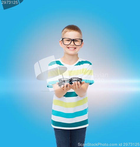 Image of smiling boy in eyeglasses holding spectacles