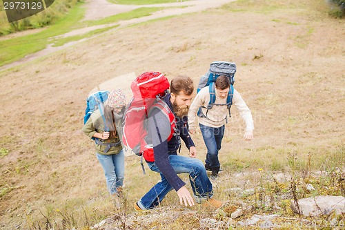 Image of group of smiling friends with backpacks hiking