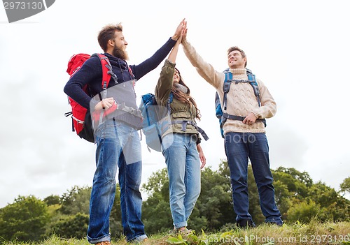 Image of group of smiling friends with backpacks hiking