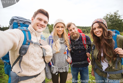 Image of group of smiling friends with backpacks hiking