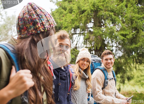 Image of group of friends with backpacks and tablet pc