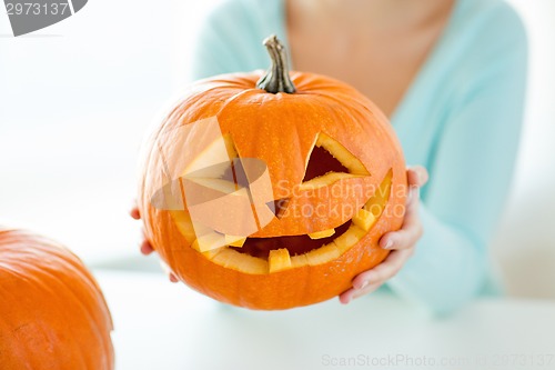 Image of close up of woman with pumpkins at home