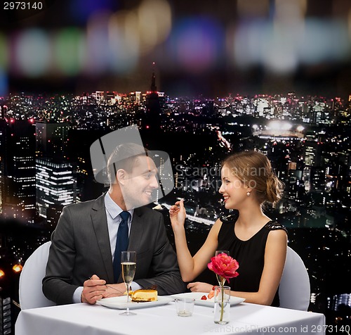 Image of smiling couple eating dessert at restaurant