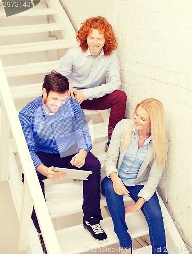 Image of team with tablet pc computer sitting on staircase