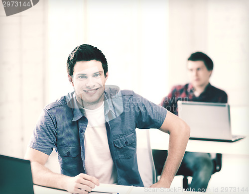 Image of smiling student with laptop at school