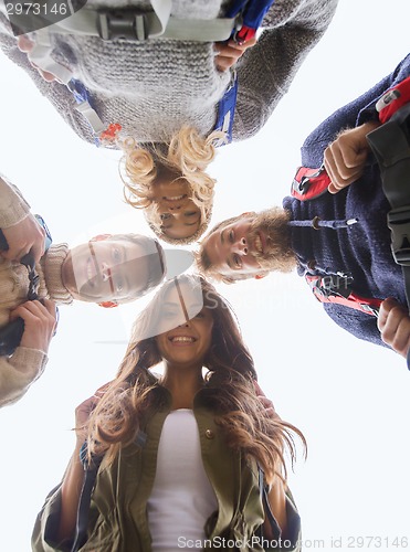 Image of group of smiling friends with backpacks hiking