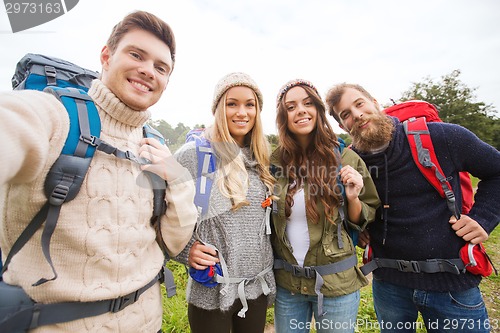 Image of group of smiling friends with backpacks hiking