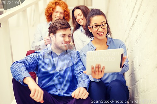 Image of team with tablet pc computer sitting on staircase
