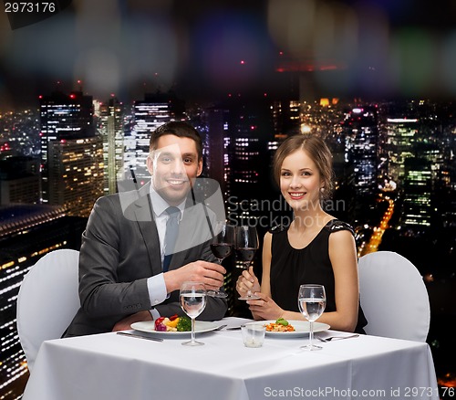 Image of smiling couple eating main course at restaurant