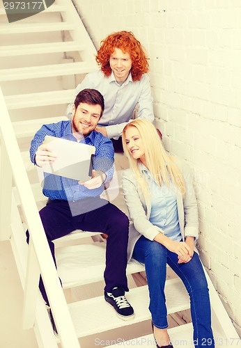 Image of team with tablet pc computer sitting on staircase