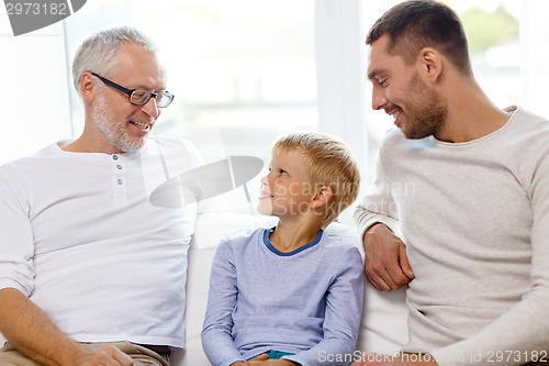 Image of smiling family sitting on couch home