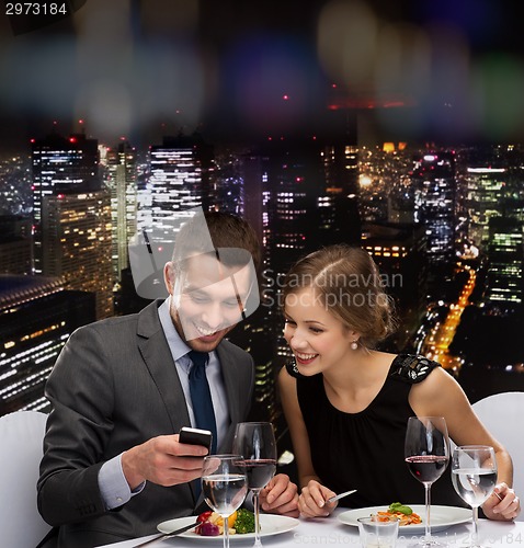 Image of smiling couple eating main course at restaurant