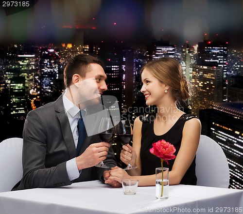 Image of young couple with glasses of wine at restaurant