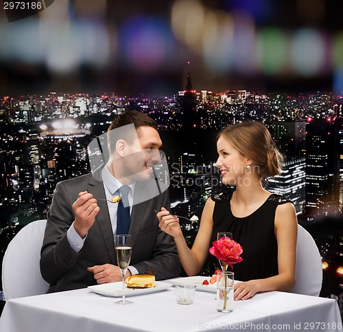Image of smiling couple eating dessert at restaurant