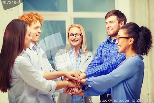 Image of team with hands on top of each other in office