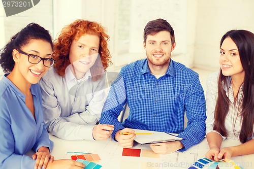 Image of team with color samples and blueprint at office