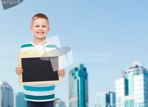 Image of smiling little boy holding blank black chalkboard