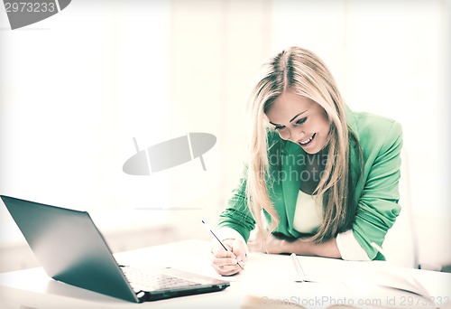 Image of smiling student girl writing in notebook