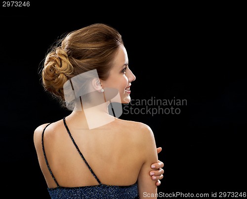 Image of smiling woman in evening dress from the back