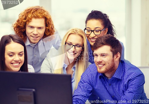 Image of smiling business team looking at computer monitor