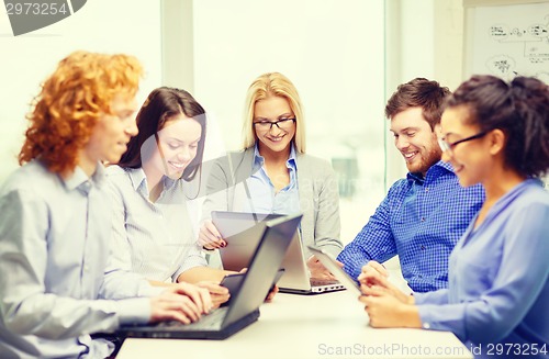 Image of smiling team with laptop and table pc computers