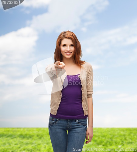 Image of smiling teenage girl pointing finger at you