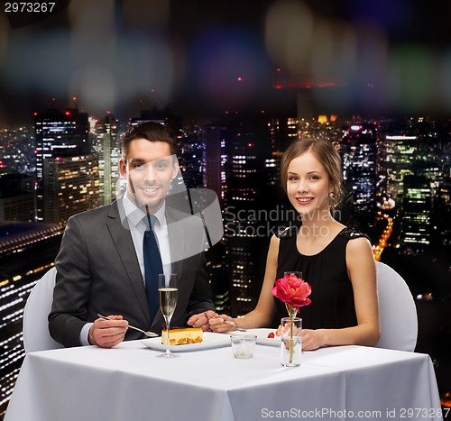 Image of smiling couple eating dessert at restaurant