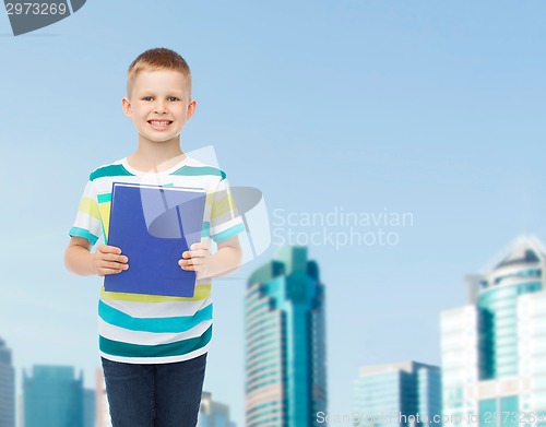 Image of smiling little student boy with blue book