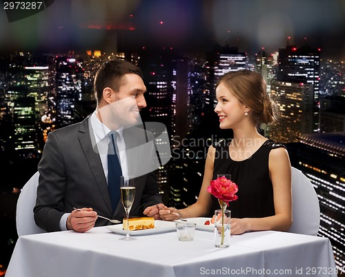 Image of smiling couple eating dessert at restaurant