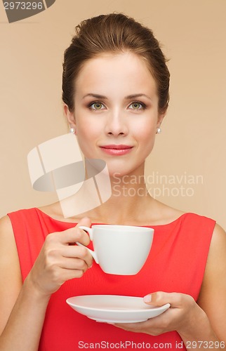 Image of smiling woman in red dress with cup of coffee