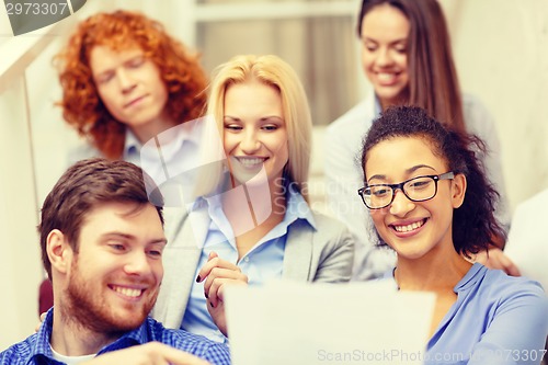 Image of team with papers and take away coffee on staircase