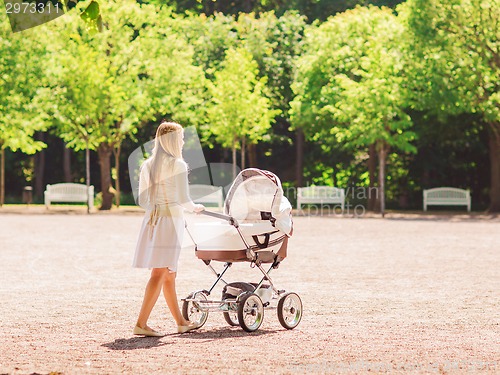 Image of happy mother with stroller in park