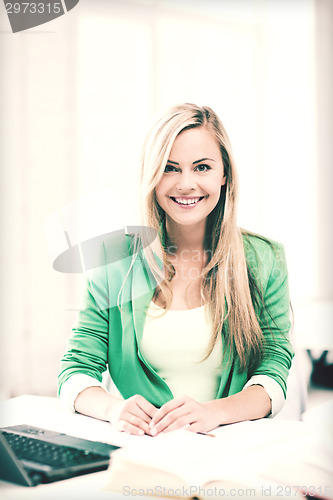 Image of smiling student girl with laptop at school