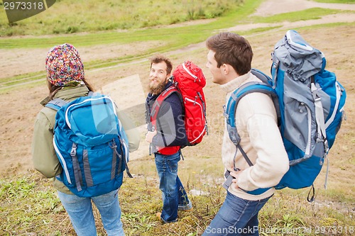 Image of group of smiling friends with backpacks hiking