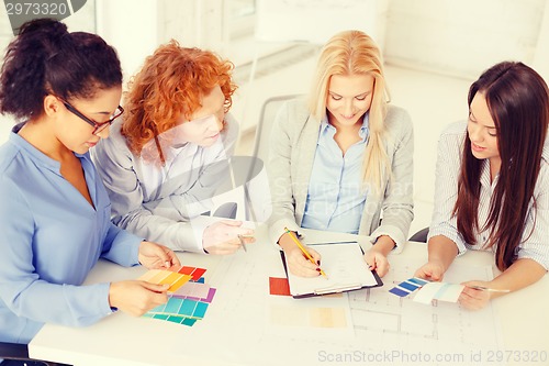 Image of team with color samples and blueprint at office