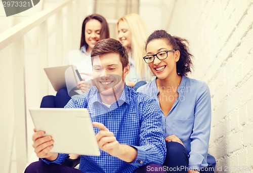 Image of team with tablet pc computer sitting on staircase